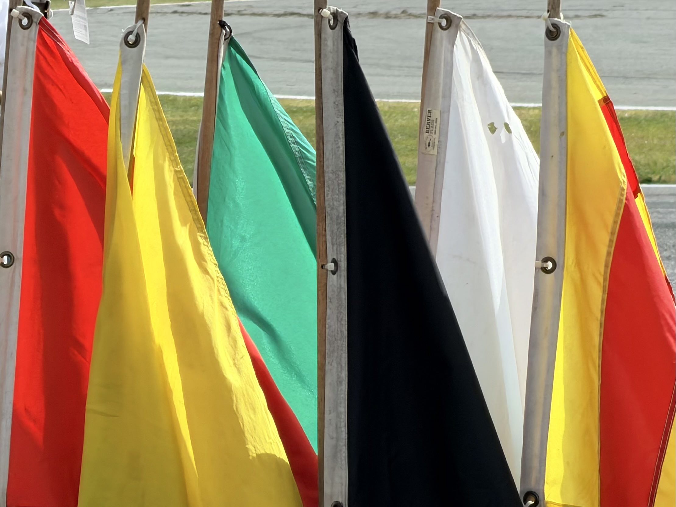 Six signalling flags arranged at the ready at a flag stand by a race track